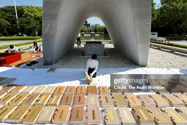 Hiroshima City officer wearing white gloves airs the name books of atomic bombs victims of Hiroshima to check whether there are any damages at...