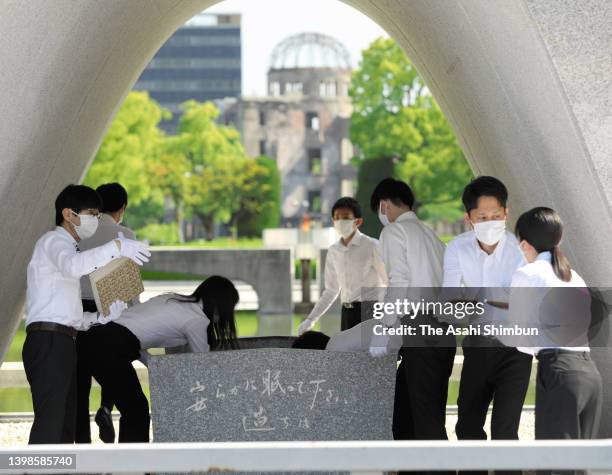 Hiroshima City officers wearing white gloves carry the name books of atomic bombs victims of Hiroshima to check whether there are any damages at...