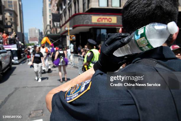 Policeman uses ice water to cool himself off on a hot day on May 21, 2022 in New York City.