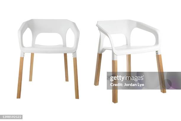 white plastic armchair with wooden legs on white background - jordan weiss stock-fotos und bilder