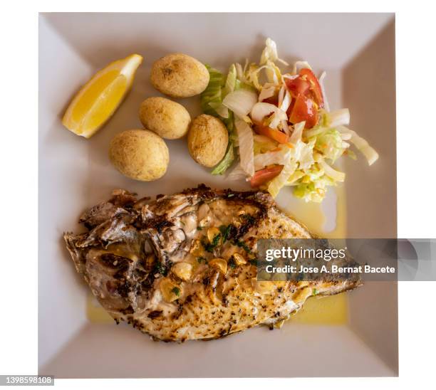 plate of grilled fish fillet (sparus aurata) with salad and potatoes on white background. - sparus aurata stock pictures, royalty-free photos & images