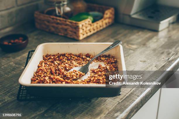 ready to eat homemade granola in a baking dish - granola stockfoto's en -beelden