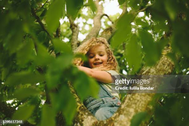 curly small girl having fun in summer park - 4 blond girls stock pictures, royalty-free photos & images