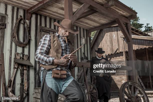 handsome black cowboy with a priest in an authentic wild west setting - historic diversity stock pictures, royalty-free photos & images
