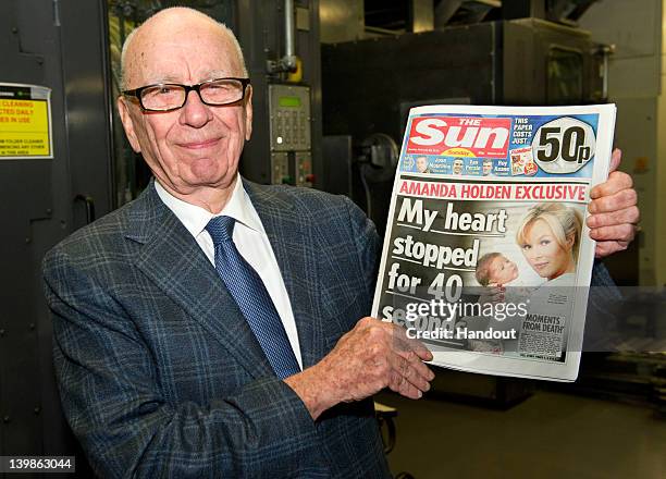 In this handout photograph provided by News International, Rupert Murdoch, Chairman and CEO of News Corporation, reviews the first edition of The Sun...