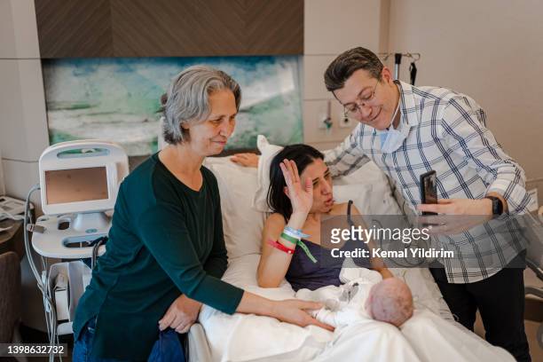 mother having video call baby in hospital ward with her family - family photo in the delivery room stock pictures, royalty-free photos & images