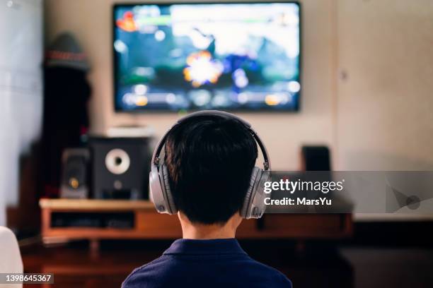 niño disfrutando de la consola de juegos en casa - china games day 1 fotografías e imágenes de stock