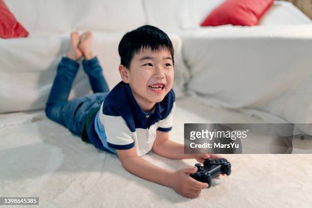 little asian boy playing video games - boys gaming stock pictures, royalty-free photos & images