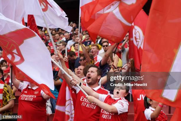 Arsenal fans wave flags prior to the Premier League match between Arsenal and Everton at Emirates Stadium on May 22, 2022 in London, England.