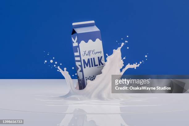 long-life milk box falling into milk and splashing - cartón de bebida fotografías e imágenes de stock