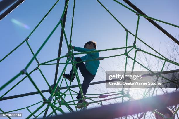 climbing on rope pyramid on playground - risk management stock pictures, royalty-free photos & images