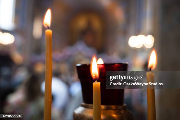 three burning candles in church interior - oosters orthodoxe kerk stockfoto's en -beelden