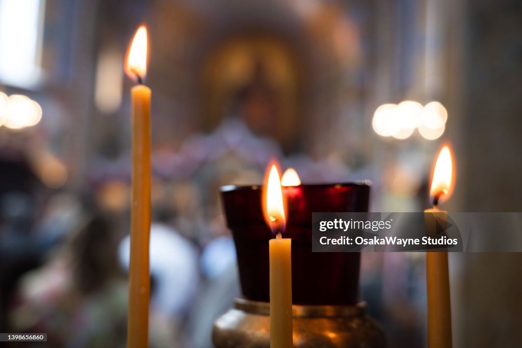 Three burning candles in church interior