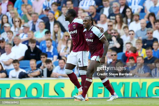 Michail Antonio of West Ham United celebrates with teammate Kurt Zouma after scoring their side's first goal during the Premier League match between...