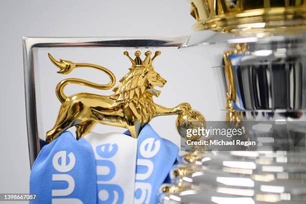 Ribbons in the colours of Manchester City are placed onto the Premier League trophy after their side finished the 2021/2022 season as champions after...