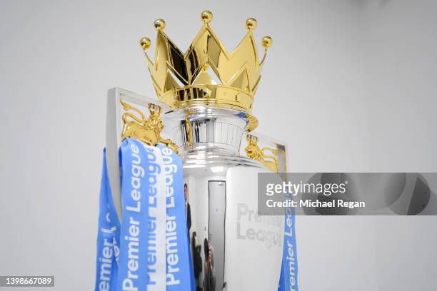 Ribbons in the colours of Manchester City are placed onto the Premier League trophy after their side finished the 2021/2022 season as champions after...
