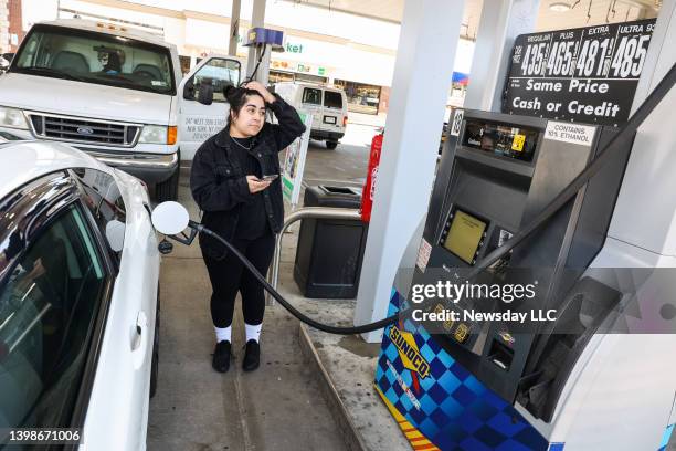 Georgina Rodriguez, of Brentwood, New York fills up her vehicle's gas tank at the Sunoco gas station in Hauppauge, New York on March 11, 2022 while...