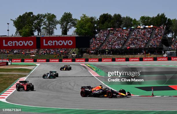 Max Verstappen of the Netherlands driving the Oracle Red Bull Racing RB18 leads Charles Leclerc of Monaco driving the Ferrari F1-75 and George...