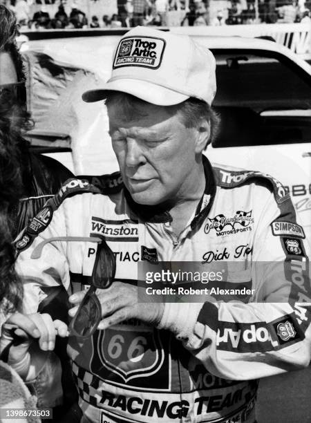 Driver Dick Trickle stands beside his racecar after competing in the 1990 Busch 500 stock car race at Bristol International Speedway in Bristol,...