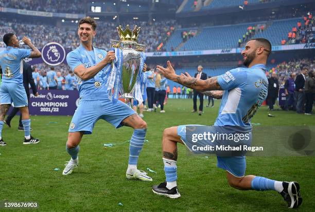 John Stones and Kyle Walker of Manchester City celebrate with the Premier League trophy after their side finished the season as Premier League...