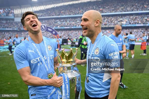 John Stones and Pep Guardiola, Manager of Manchester City celebrate with the Premier League trophy after their side finished the season as Premier...