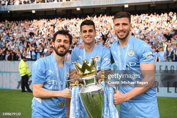 Bernardo Silva, Joao Cancelo and Ruben Dias of Manchester City pose with the Premier League trophy after their side finished the season as Premier...