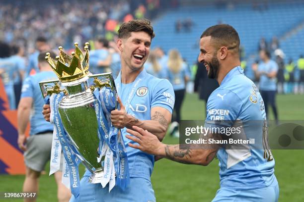 John Stones and Kyle Walker of Manchester City celebrate with the Premier League trophy after their side finished the season as Premier League...