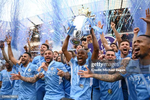 Ruben Dias and Bernardo Silva of Manchester City lift the Premier League trophy after their side finished the season as Premier League champions...