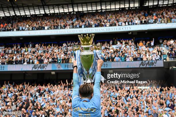 Jack Grealish of Manchester City lifts the Premier League trophy in front of fans after their side finished the season as Premier League champions...