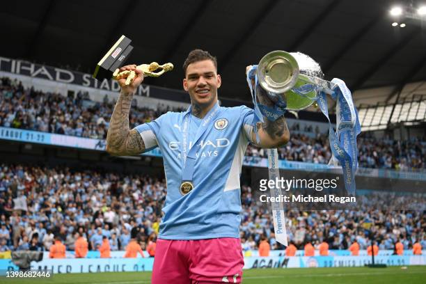 Ederson of Manchester City celebrates with the Premier League trophy after their side finished the season as Premier League champions and the Golden...