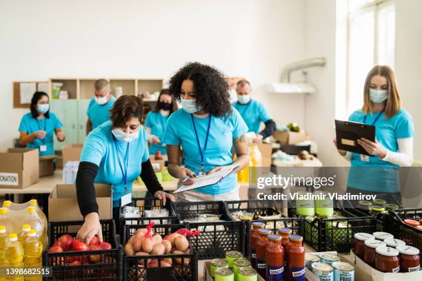 voluntarios que realizan donaciones durante la colecta de alimentos - food pantry fotografías e imágenes de stock