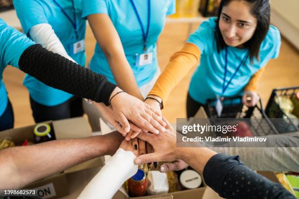 elevated view of a circle of stacked hands - philanthropist stock pictures, royalty-free photos & images