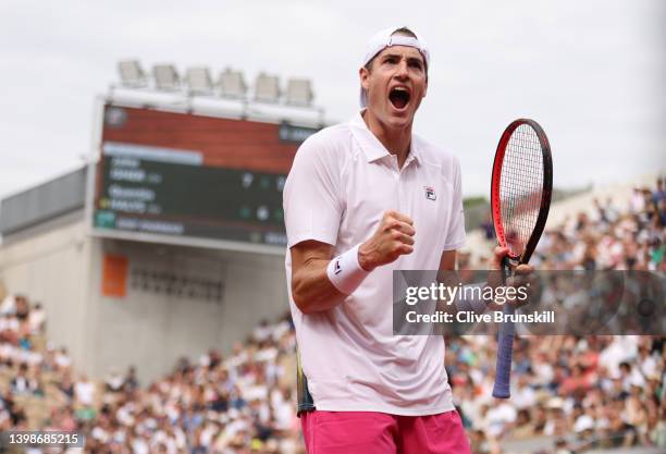 John Isner of the United States celebrates match point against Quentin Halys of France in their mens singles first round match during the 2022 French...