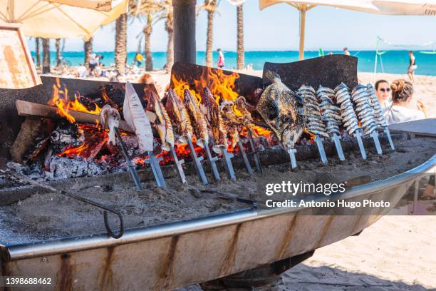 sardines, squid and other fish grilled at a beach bar in malaga, spain. - charcoal food stock pictures, royalty-free photos & images