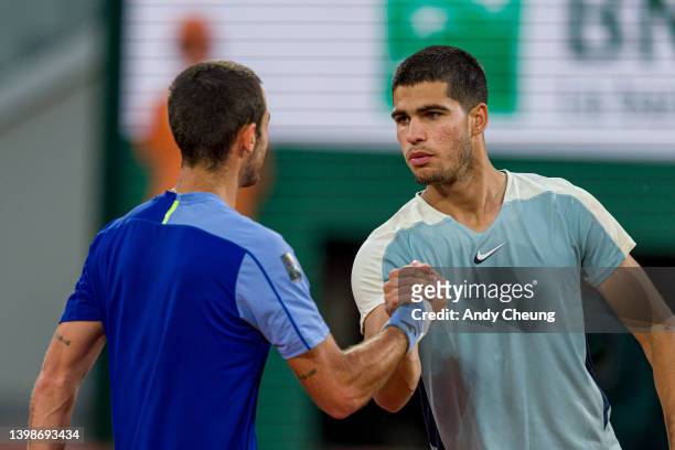 Carlos Alcaraz of Spain shakes hands with Juan Ignacio Londero of Argentina after winning match point during the Men's Singles First Round match on...
