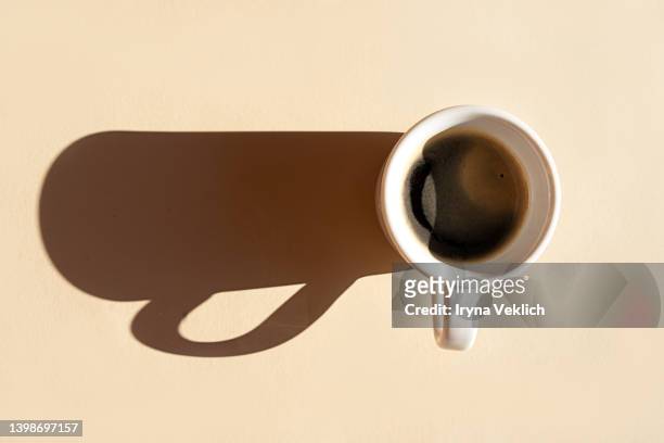 aromatic morning coffee and a long shadow from the cup. - espressomaschine stock-fotos und bilder
