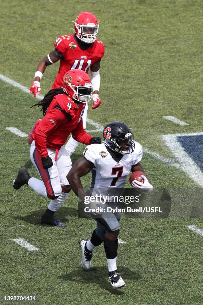 Mark Thompson of the Houston Gamblers runs with the ball as D'Juan Hines and De'Vante Bausby of the New Jersey Generals defends in the first quarter...