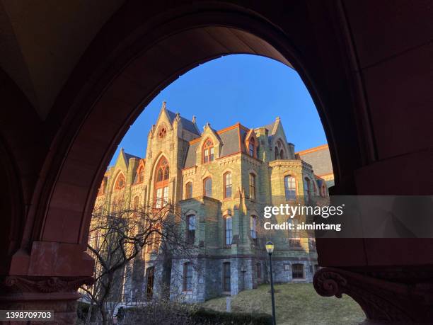 view of college hall through arched door - university of pennsylvania stock pictures, royalty-free photos & images