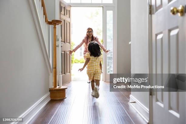 toddler girl running to greet mother in doorway as she gets home from work - welcome yellow stock pictures, royalty-free photos & images