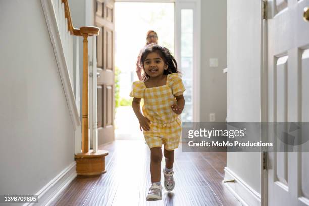 toddler girl running to greet mother in doorway as she gets home from work - girl in yellow dress stock pictures, royalty-free photos & images
