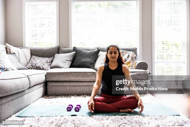 woman exercising at home - yoga rug photos et images de collection