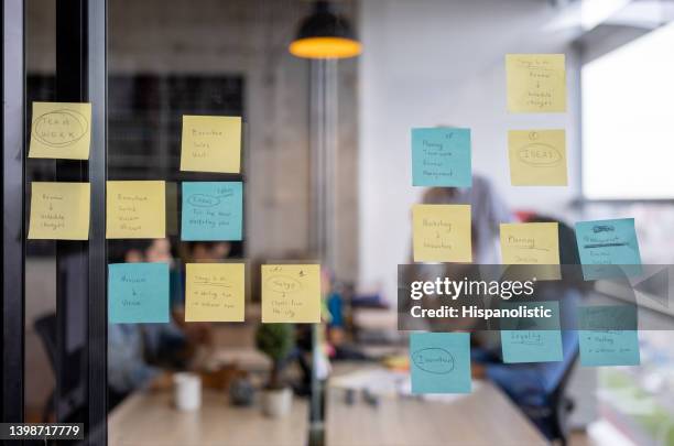 geschäftsstrategie, die auf einer tafel mit post its geschrieben wurde - brainstorming stock-fotos und bilder