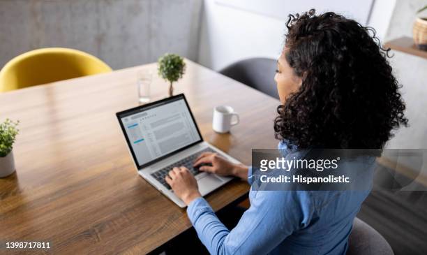business woman working at the office using a laptop computer - inbox stockfoto's en -beelden