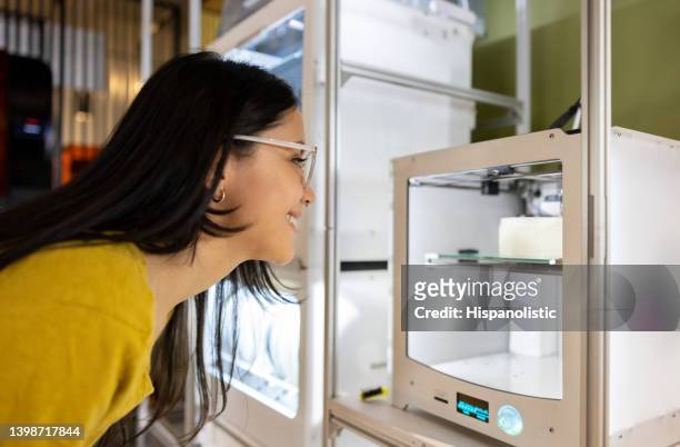 woman watching a 3d printer printing a model - 3 d printing stock pictures, royalty-free photos & images
