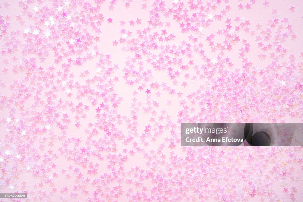 Many small pink stars on pink background. Holiday concept. Flat lay style