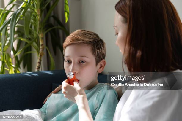 kid boy using an asthma inhaler during illness. - cystic fibrosis 個照片及圖片檔