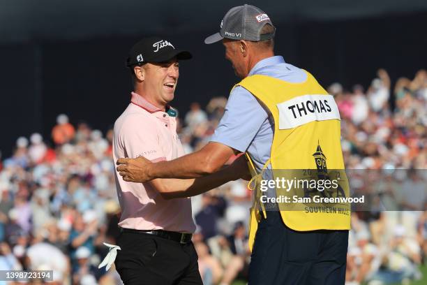 Justin Thomas of the United States reacts to his winning putt on the 18th hole with caddie Jim "Bones" Mackay, the third playoff hole during the...