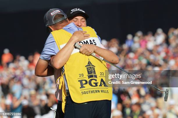 Justin Thomas of the United States reacts to his winning putt on the 18th hole with caddie Jim "Bones" Mackay, the third playoff hole during the...