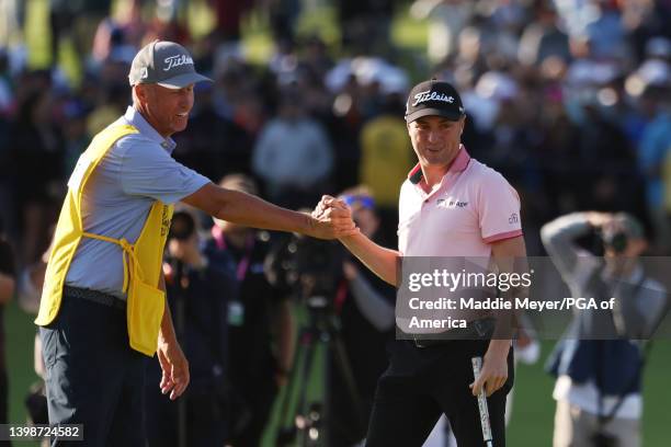 Justin Thomas of the United States reacts to his winning putt on the 18th hole with caddie Jim "Bones" Mackay, the third playoff hole during the...