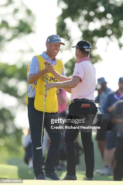 Justin Thomas of the United States reacts to his winning putt on the 18th hole with caddie Jim "Bones" Mackay, the third playoff hole during the...